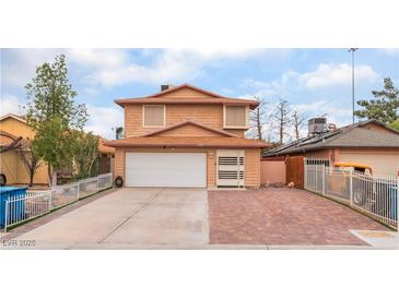 Two-story home featuring a large driveway, a two-car garage, and low-maintenance landscaping at 3744 Archer St, Las Vegas, NV 89108