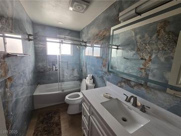 Modern bathroom featuring marbled walls, a tub-shower, and a white vanity with undermount sink at 4342 E Russell Rd, Las Vegas, NV 89120