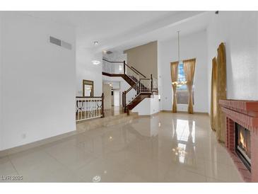 Bright, open living room with staircase, fireplace, and tile floors at 738 Panhandle Dr, Henderson, NV 89014