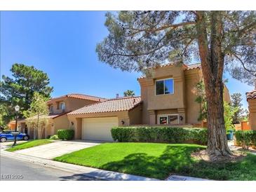 Charming home boasts a two-car garage, mature landscaping, and a red tile roof at 7711 Spanish Lake Dr, Las Vegas, NV 89113