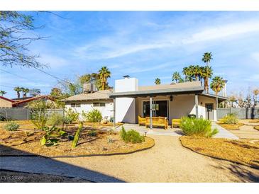Charming home featuring a large backyard with mature trees and a covered patio seating area at 1513 Kirkland Ave, Las Vegas, NV 89102