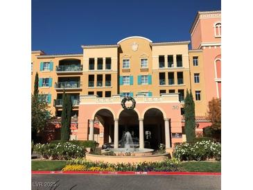 Beautiful condo building featuring balconies, a fountain, arched entry, and manicured landscaping at 30 Strada Di Villaggio # 439, Henderson, NV 89011