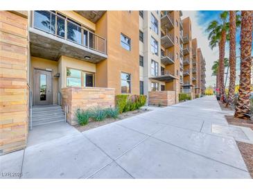 Beautiful condo exterior featuring multiple levels, balconies, and meticulous landscaping with palm trees at 353 E Bonneville Ave # 125, Las Vegas, NV 89101