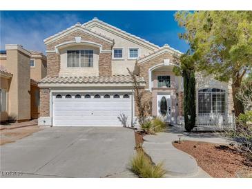 Charming two-story home featuring a large front yard, two-car garage, and stone and stucco facade at 8988 Dusseldorf Way, Las Vegas, NV 89147
