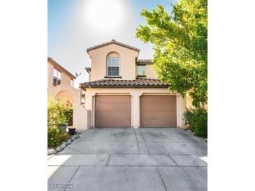 Two-story home featuring a two-car garage, neutral stucco, and well-maintained landscaping at 2431 Lilac Cove St, Las Vegas, NV 89135