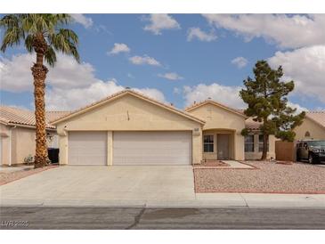 Charming single-story home features a two-car garage, desert landscaping, and a tiled roof at 3320 Helmsman Dr, North Las Vegas, NV 89032