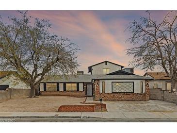 Charming single-story home with brick accents, mature trees and a driveway at 4155 Comb Cir, Las Vegas, NV 89104