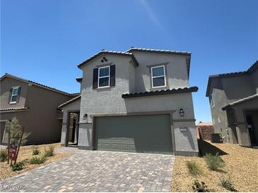 Two-story home featuring a gray stucco exterior, attached garage, and well manicured landscaping at 5180 Hisopo St # Lot 24, Las Vegas, NV 89122