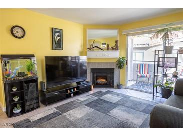 Inviting living room with a cozy fireplace, neutral-toned walls, and an outdoor patio at 5206 Mandalay Springs Dr # 204, Las Vegas, NV 89120