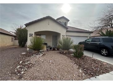 Charming single-story home featuring desert landscaping and a covered front porch, complemented by an attached two-car garage at 5240 Adorato Dr, North Las Vegas, NV 89031