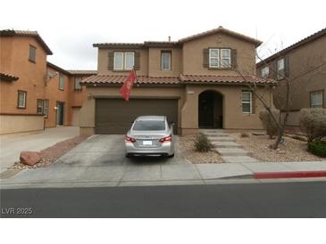 Charming two-story home with a two-car garage, landscaped front yard, and a warm, inviting entrance at 668 Moonlight Stroll St, Henderson, NV 89002