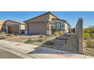 Charming single-story home featuring a two-car garage, desert landscaping, and a walkway to a private entry at 9698 Pacific Pine St, Las Vegas, NV 89143