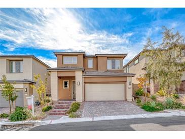 Two-story tan home features a two-car garage and low maintenance desert landscaping at 12397 Foxtail Run Ave, Las Vegas, NV 89138