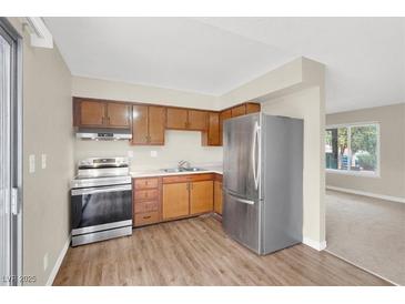 Traditional kitchen with stainless steel appliances and wood cabinets, offering a functional cooking space at 317 E Van Wagenen St, Henderson, NV 89015