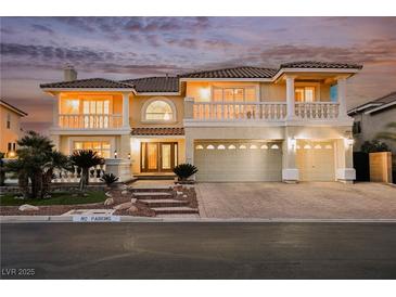Two-story home with a three-car garage, tile roof, and manicured landscaping at 4384 Grey Spencer Dr, Las Vegas, NV 89141