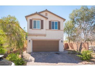 Charming two-story home featuring a two-car garage, desert landscaping, and a classic stucco exterior with brown shutters at 6487 W Levi Ave, Las Vegas, NV 89141