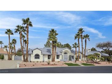 Inviting single-story home with lush palm trees and meticulous desert landscaping at 8112 Golfers Oasis Dr, Las Vegas, NV 89149