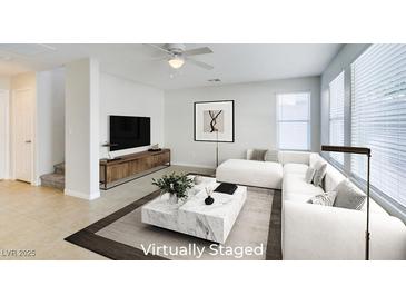 Bright, open living room features tile floors, modern decor, and a comfortable white sectional sofa at 9092 Sosa Creek Ave, Las Vegas, NV 89149