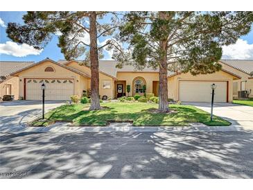 Charming single-story home with a well-manicured lawn, mature trees, and a two-car garage at , Las Vegas, NV 89130