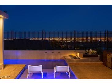 Inviting pool with city view and lounge chairs perfect for relaxing outdoors after dark at 294 Besame Ct, Las Vegas, NV 89138