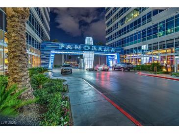 Night shot of a condominium entrance with prominent signage, landscaping, and circular driveway at 4525 Dean Martin Dr # 911, Las Vegas, NV 89103