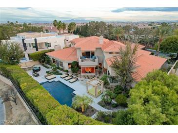 Expansive home showcasing a pool, lounge area, lush greenery, and a terracotta roof at 60 Innisbrook Ave, Las Vegas, NV 89113
