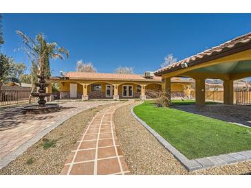 Charming single-story home with a terracotta roof, well-manicured lawn, and beautiful water fountain at 6151 Whispering Sands Dr, Las Vegas, NV 89131
