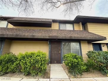 Inviting two-story townhouse with a well-maintained exterior and landscaped front yard at 6174 Meadowgrass Ln, Las Vegas, NV 89103
