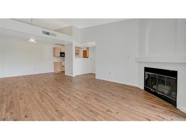 Bright living room with light walls, wood floors, and a corner fireplace at 7885 W Flamingo Rd # 2012, Las Vegas, NV 89147