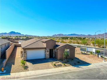 Charming single-story home with a neutral-colored exterior, desert landscaping, and mountain views at 1005 Warsaw Ave, Henderson, NV 89015