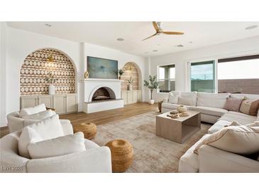 Bright living room featuring a fireplace, modern ceiling fan, and large sliding doors to the backyard at 10420 Luella Ct, Las Vegas, NV 89143