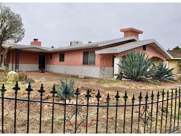 Charming single-story home with unique desert landscaping and a decorative black metal fence at 1201 Madison Ave, Las Vegas, NV 89106
