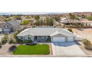 Charming single-story home featuring a well-manicured lawn and a three-car garage at 1395 Logandale Dr, Logandale, NV 89021