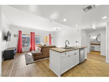 Bright living room with a view of the outdoor, an open kitchen and bathroom entrance at 30 Strada Di Villaggio # 409, Henderson, NV 89011
