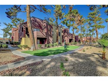 Multi-Gathering building featuring well-maintained landscaping, mature trees, and a walking path at 4050 Pacific Harbors Dr # 233, Las Vegas, NV 89121