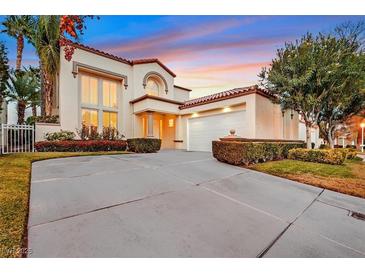 Elegant two-story home featuring a spacious driveway, manicured landscaping, and a tile roof at 8390 Carmel Ridge Ct, Las Vegas, NV 89113