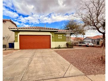 Charming single-story home featuring an orange garage door and gravel landscaping at 1080 Laguna Park Ct, Las Vegas, NV 89110