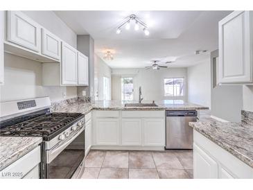 Bright kitchen features stainless steel appliances, granite counters, and white cabinets at 1634 Clint Canyon Dr, Henderson, NV 89002