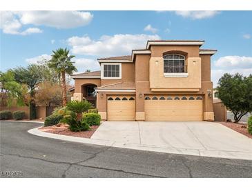 Two-story stucco home featuring a three-car garage and well-maintained landscaping at 2337 Ivory Point Ct, Las Vegas, NV 89134