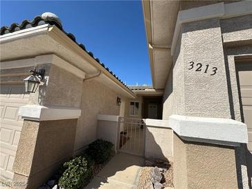 Inviting single-story home featuring a stucco exterior, a gated entrance, and a well-maintained front yard at 3213 Partridge Run St, Laughlin, NV 89029