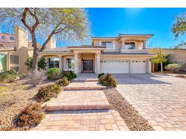 Inviting two-story home with a three-car garage, manicured front yard, and a brick-paved walkway at 4481 Grey Spencer Dr, Las Vegas, NV 89141