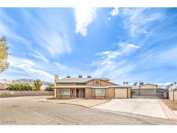 Charming two-story home with desert landscaping, spacious driveway, and secure gated entrance at 5751 E Owens Ave, Las Vegas, NV 89110