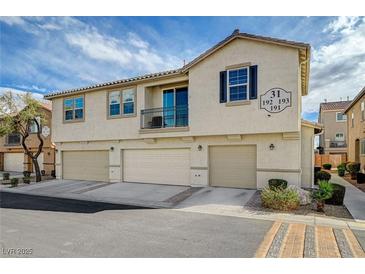 Two-story townhome featuring multiple garage spaces and neutral stucco exterior at 6255 W Arby Ave # 193, Las Vegas, NV 89118