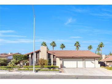 Charming single-story home features a three-car garage, red tile roof, and mature landscaping at 8620 Cremona Dr, Las Vegas, NV 89117