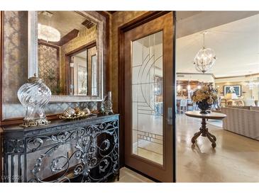 Elegant foyer with decorative console table, mirror, and glass paneled entry door, leading to a spacious living area at 9103 Alta Dr # 602, Las Vegas, NV 89145