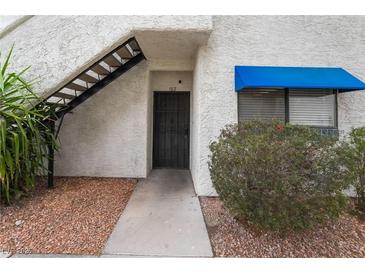 Inviting entryway featuring a secure black security door and a bright blue awning over the window at 2673 Red Rock St # 102, Las Vegas, NV 89146