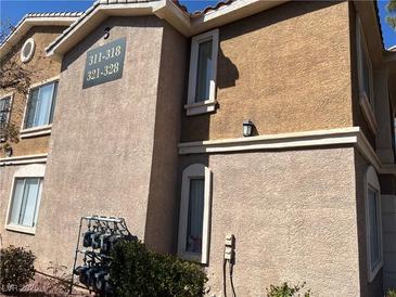 Exterior angle of a tan apartment building with beige trim, showcasing a secure gas meter setup and clean windows at 2900 Sunridge Heights Pkwy # 327, Henderson, NV 89052