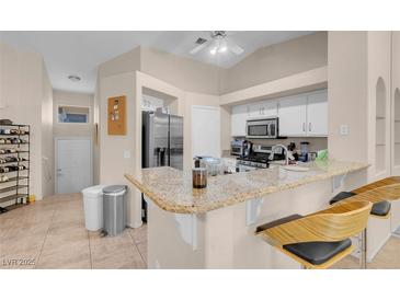Bright kitchen features modern appliances, granite counters, and bar seating area at 5000 Red Rock St # 241, Las Vegas, NV 89118