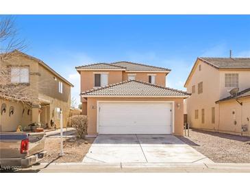 Two story tan home with a two car garage, tile roof, and well-kept lawn in a suburban neighborhood under a blue sky at 5935 Stone Hollow Ave, Las Vegas, NV 89156