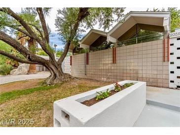 View of the home's mid-century modern architecture and block wall with planter at 2058 Ottawa Dr, Las Vegas, NV 89169
